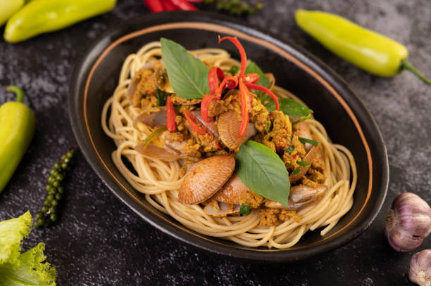 istock Spaghetti with Clams in a Black Plate with Chilies Fresh garlic and pepper. 1428869832