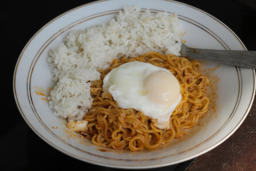 Fried noodles with spicy grilled chicken with fried eggs and warm rice
