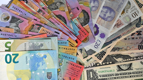 Different types of international paper money scattered on a table