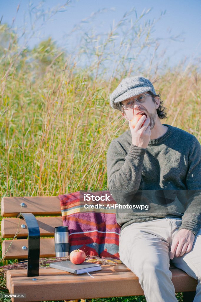 eating apple The man is enjoyinga fresh autumn apple while relaxing at the assiniboine forest Forest Stock Photo