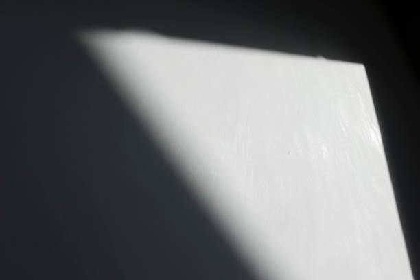 Abstract background with black wall and window shadow with sunlight. The geometric shape of the pattern on the concrete