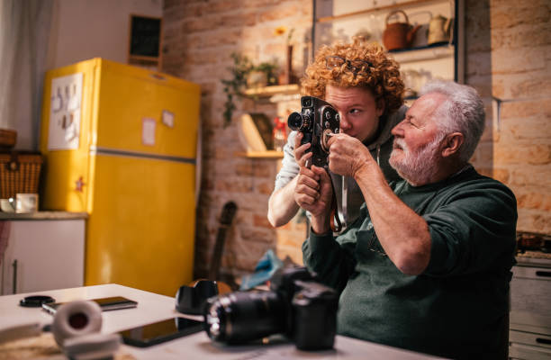 istock grandpa explaining grandson how to use retro camera 1428916491
