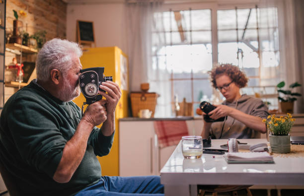 istock grandpa explaining grandson how to use retro camera 1428916647