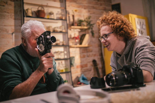 istock grandpa explaining grandson how to use retro camera 1428916650