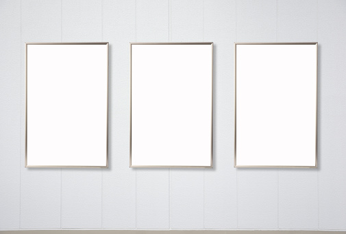 Row of blank metal picture frames mockup on white wall with copy space.