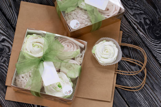 homemade marshmallows in a gift box. tied with ribbon. paper bag from craft paper. zephyr flowers. on black pine boards. taken from above. - craft chocolate candy black box imagens e fotografias de stock