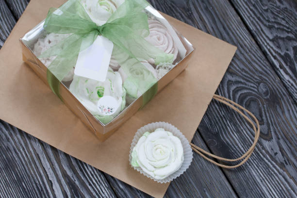 homemade marshmallows in a gift box. tied with ribbon. paper bag from craft paper. zephyr flowers. on black pine boards. taken from above. - craft chocolate candy black box imagens e fotografias de stock