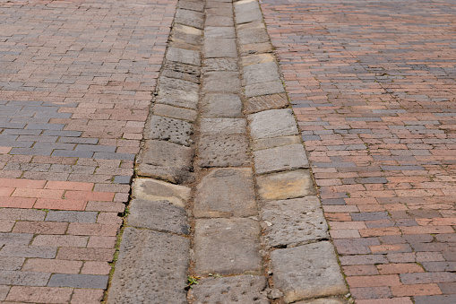 Old rock drain in a brick street in sydney's historic Rocks area.