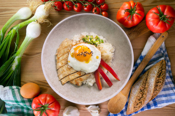 istock Teriyaki chicken donburi with fried egg, onion, red pepper and other vegetables. Typical Japanese dish. 1428930515
