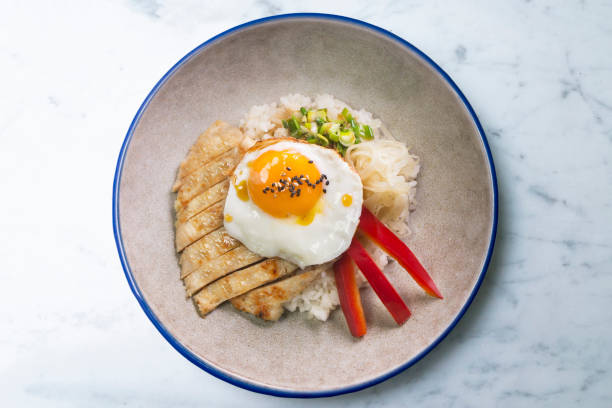 istock Teriyaki chicken donburi with fried egg, onion, red pepper and other vegetables. Typical Japanese dish. 1428930526