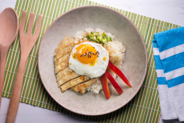 istock Teriyaki chicken donburi with fried egg, onion, red pepper and other vegetables. Typical Japanese dish. 1428930541