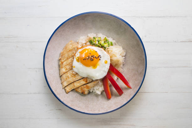 istock Teriyaki chicken donburi with fried egg, onion, red pepper and other vegetables. Typical Japanese dish. 1428930670