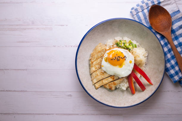 istock Teriyaki chicken donburi with fried egg, onion, red pepper and other vegetables. Typical Japanese dish. 1428930681