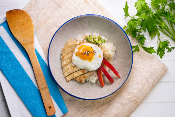 istock Teriyaki chicken donburi with fried egg, onion, red pepper and other vegetables. Typical Japanese dish. 1428930686