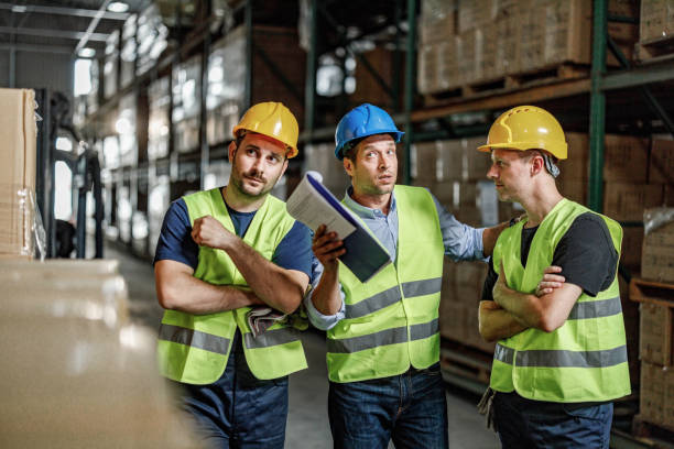 istock Manager giving instructions to his workers in distribution warehouse. 1428935651