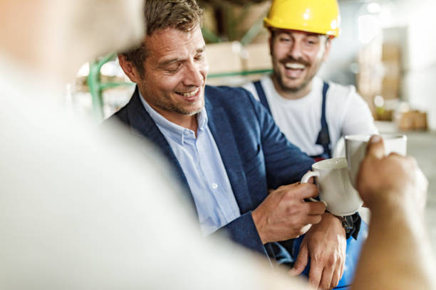 istock Happy manager toasting with his workers on coffee break in storage room. 1428935732