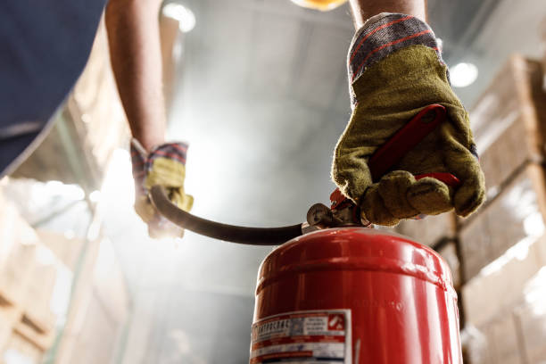 istock Close up of using fire extinguisher in a warehouse. 1428935777
