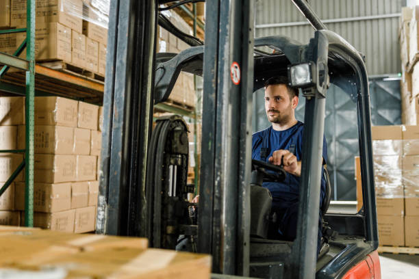 istock Young warehouse worker driving a forklift in a storage room. 1428936599