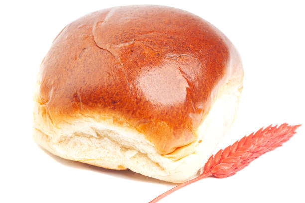 istock fresh baked wheat buns with wheat ears isolated on white 1428939072