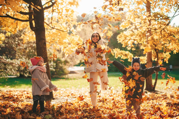 istock Happy family throwing autumn leaves 1428939956