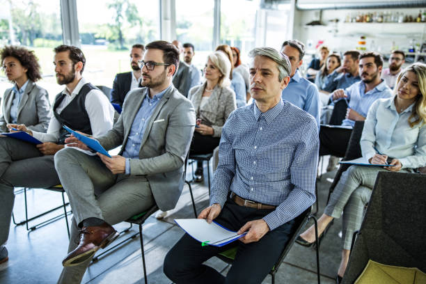 istock Large group of business people attending a training class in a board room. 1428941015