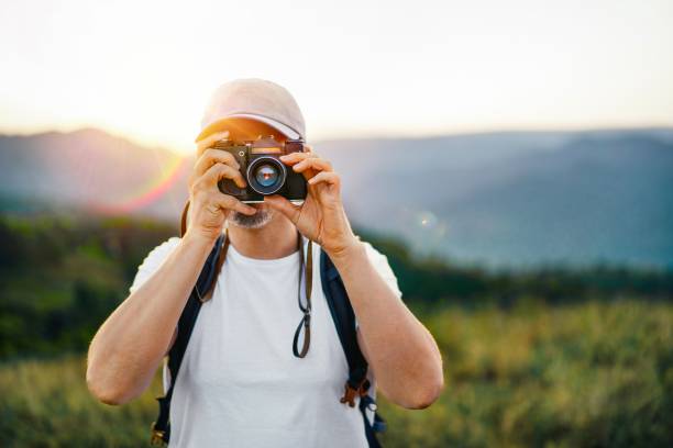 homme prenant des photos sur la montagne au coucher du soleil - romania men artist portrait photos et images de collection