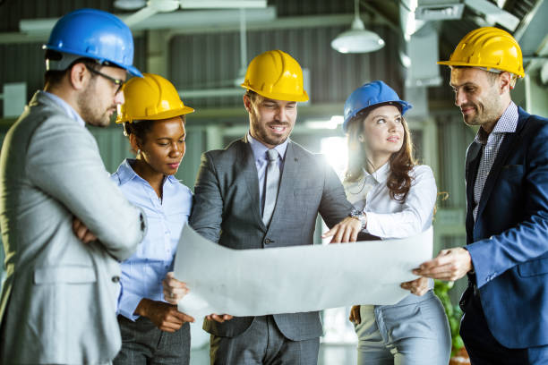 istock Team of building contractors analyzing business plan in the office. 1428942353