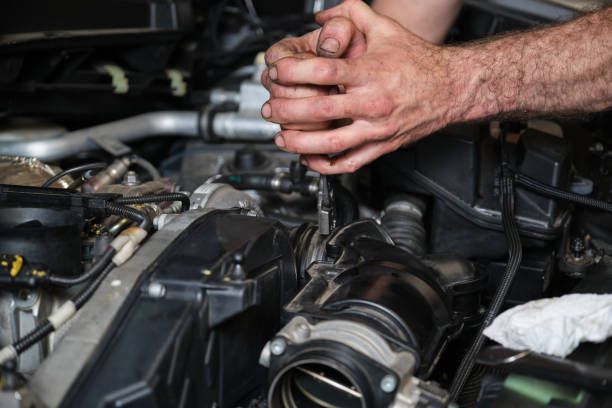 istock Car mechanic hands replacing engine throttle body. 1428944553