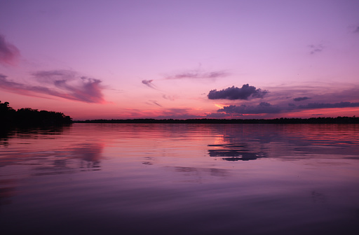 Purple rose sunset over quiet calm waters,