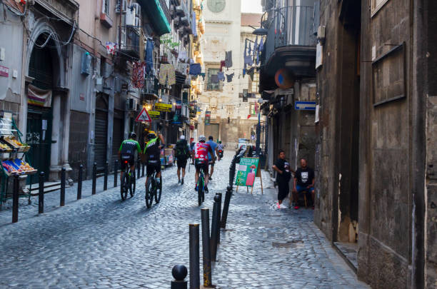 Cyclists walk along the Street of Old Naples. stock photo