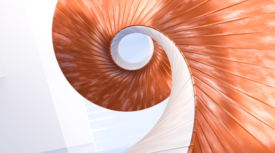 Abstract staircase detail seen from below, forming a spiral with golden proportions. White walls with copper orange elements resembling steps, almost giving feeling of vertigo. Abstract architectural background with copy space.