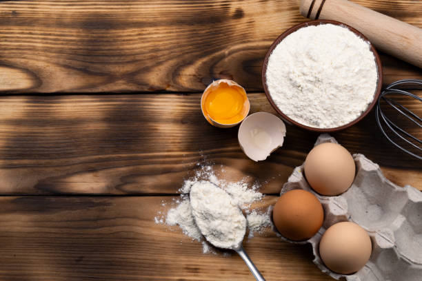 istock Ingredients for baking: flour, eggs, yolk on a wooden background. Flat lay. Space for text. Top view. 1428952615