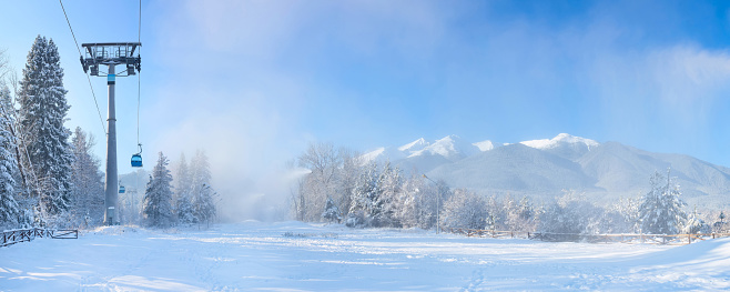 Bansko, Bulgaria winter ski resort banner panorama with forest pine trees, Pirin mountain peaks view and gondola cabins