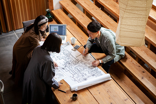 Planning team of three people.
30s, 40s Japanese man and women.
They have an architectural design meeting in the office.