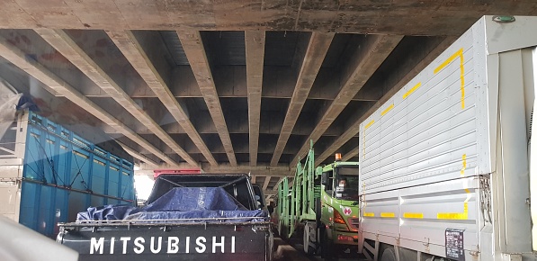Jakarta, Indonesia in August 2019. Rear view photo of cars and trucks that are in a toll road jam. When stuck the vehicle runs slowly and sometimes stops.