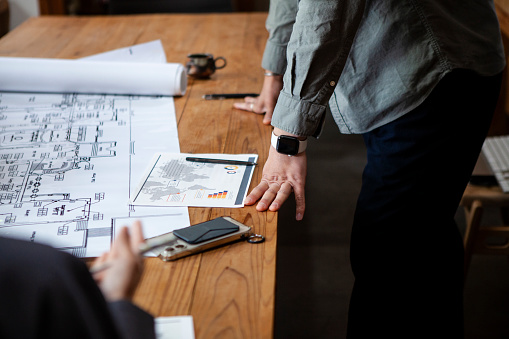 A planning team of 3 people.
Japanese men and women in their 30s-40s.
They hold a building design meeting in the office.