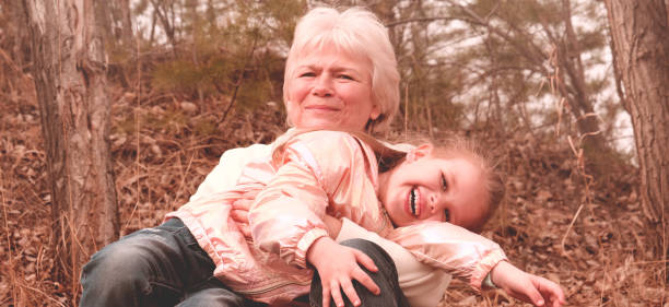 happy grandmother with granddaughter together. grandchild hugs his beloved grandmother, happy autumn time. toned image, vintage soft filter - great grandchild imagens e fotografias de stock