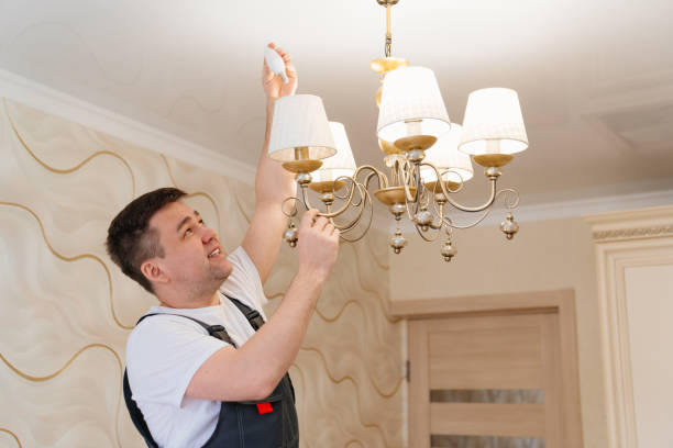 istock A male electrician changes the light bulbs in the ceiling light. 1428957395