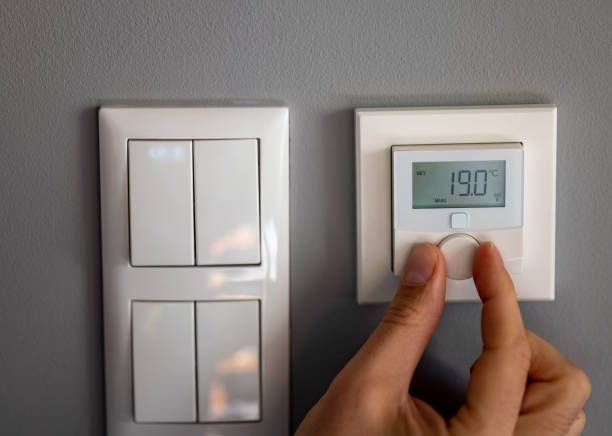 istock Hand turns down the temperature to 19 degrees Celsius on a electronic thermostat. Symbol for saving energy. 1428962569