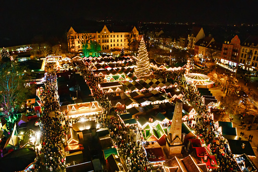 Traditional Christmas market in Erfurt, Thuringia in Germany. With xmas tree, pyramide and sales and food stands on late evening or night.