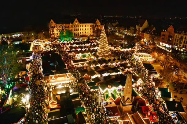 Traditional Christmas market in Erfurt, Thuringia in Germany. With xmas tree, pyramids and sales and food stands on late evening or night