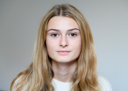 Portrait of female with light brown hair and blond hair highlights, studio shot.