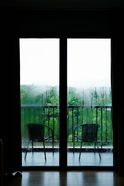 istock Frame of wet dark windows with raining outside. 1428971147