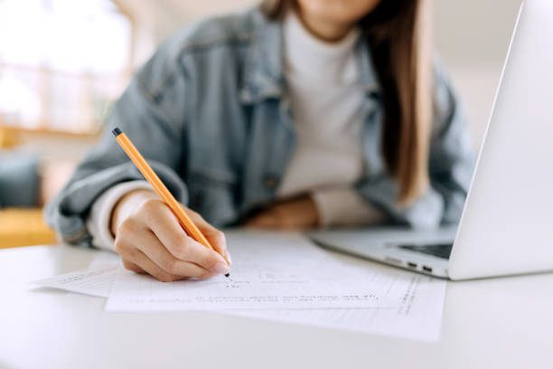 istock Close up of an unrecognisable young woman writing on document 1428977229