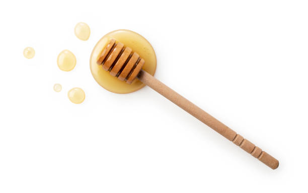 istock Wooden honey dipper with honey on white background. 1428979776