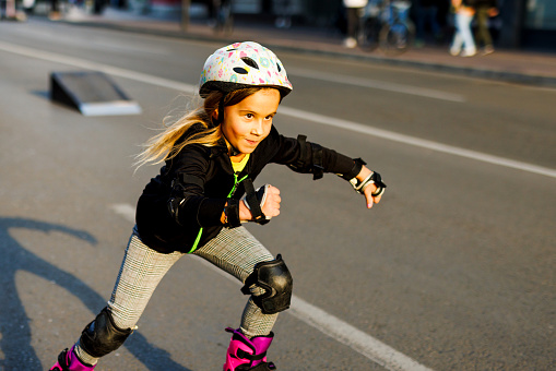 Cute little girl rides roller skates