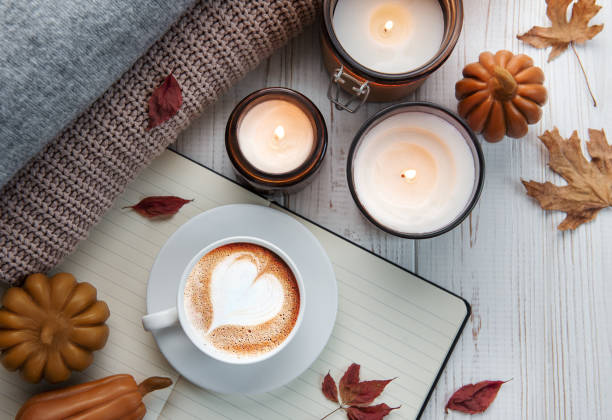 pose plate d’automne de café, biscuits, feuilles d’automne, bougie sur fond blanc en bois. - coffee pumpkin latté autumn photos et images de collection