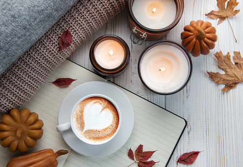 Autumn cozy composition. Autumn flat lay of coffee,cookies, fall leaves, candle on wooden white background.  Autumn, fall concept. Flat lay, top view.