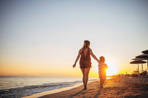 istock A mother and her son walking on the beach 1428985184