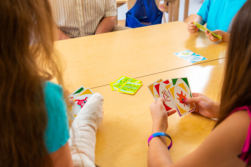 School children playing card game in classroom. Model released. Playing cards and school are Property released for commercial use.